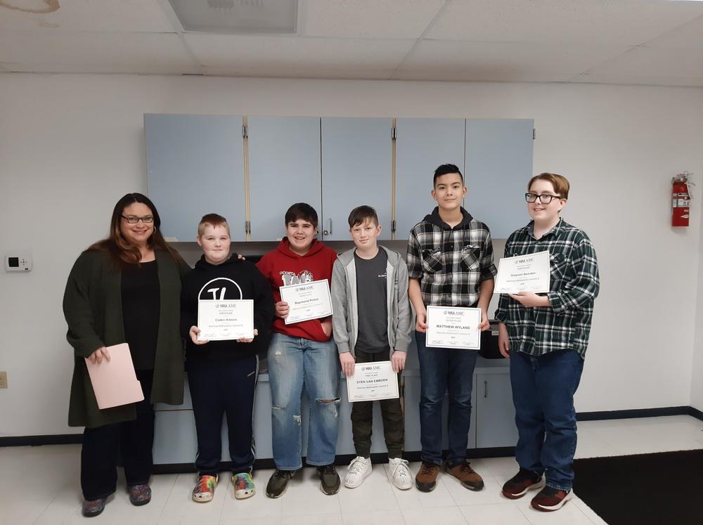 Adult and five students standing in a room holding certificates